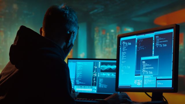 Person vor mehreren Monitoren